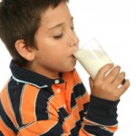少年享用一杯新鲜的牛奶