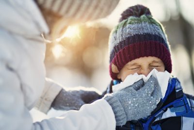 在感冒和流感季节，妈妈用纸巾给孩子擤鼻涕