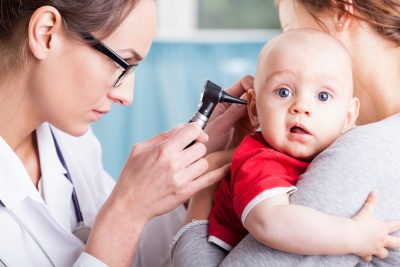 医生在康复期间检查婴儿的耳朵