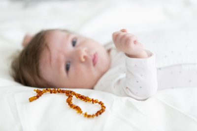 婴儿躺在琥珀项链旁边
