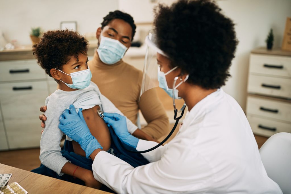 医生检查孩子的肺以确保他们是健康的，而家长则在一旁看着